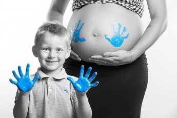 Color-Key-Aufnahme von Babybauch mit Handabdrücken des Sohnes