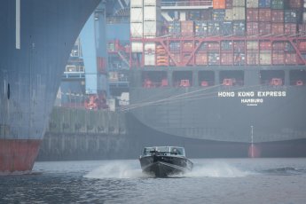 Das Angelboot Black Pearl zwischen Containerriesen