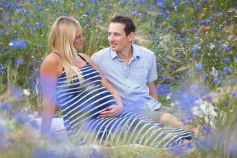 Schwangerschaftsfoto: Junges Paar im Blumenfeld