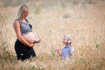 Schwangere Mutter im Kornfeld mit kleinem Sohn