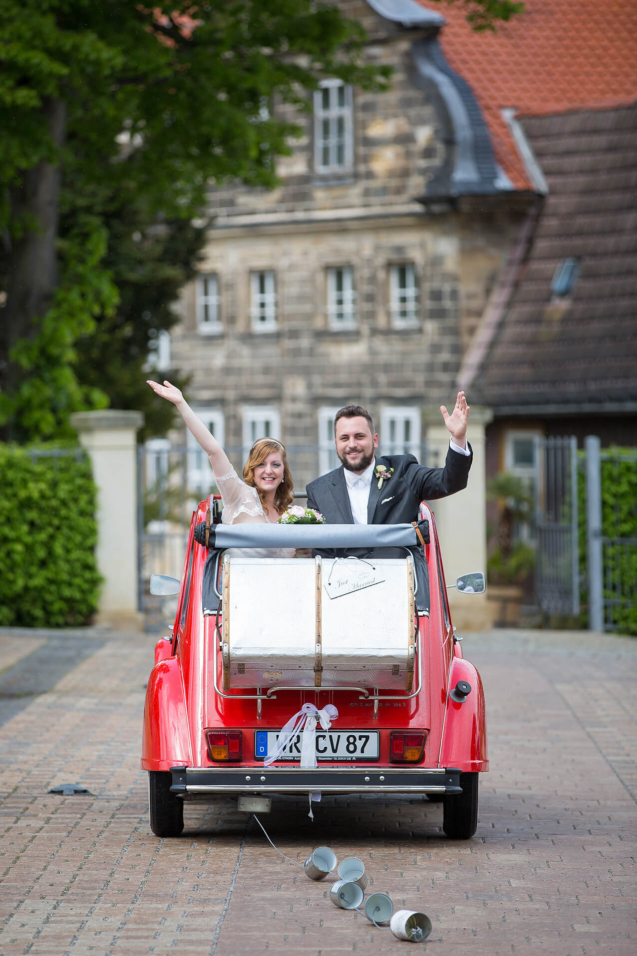 Brautpaar im Hochzeitswagen – eine rote Ente