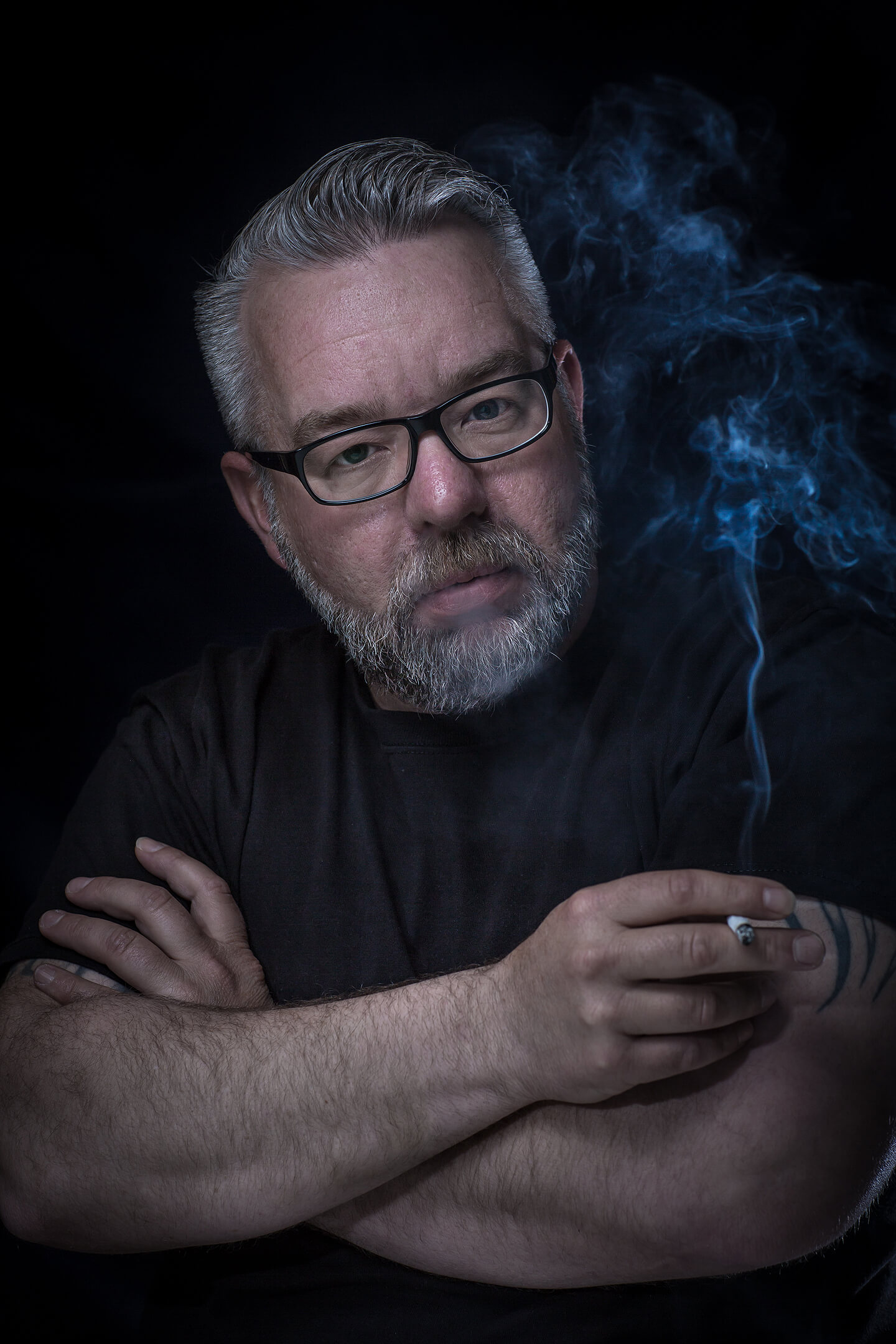 Portraitfoto Mann mit grauem Bart und Zigarette