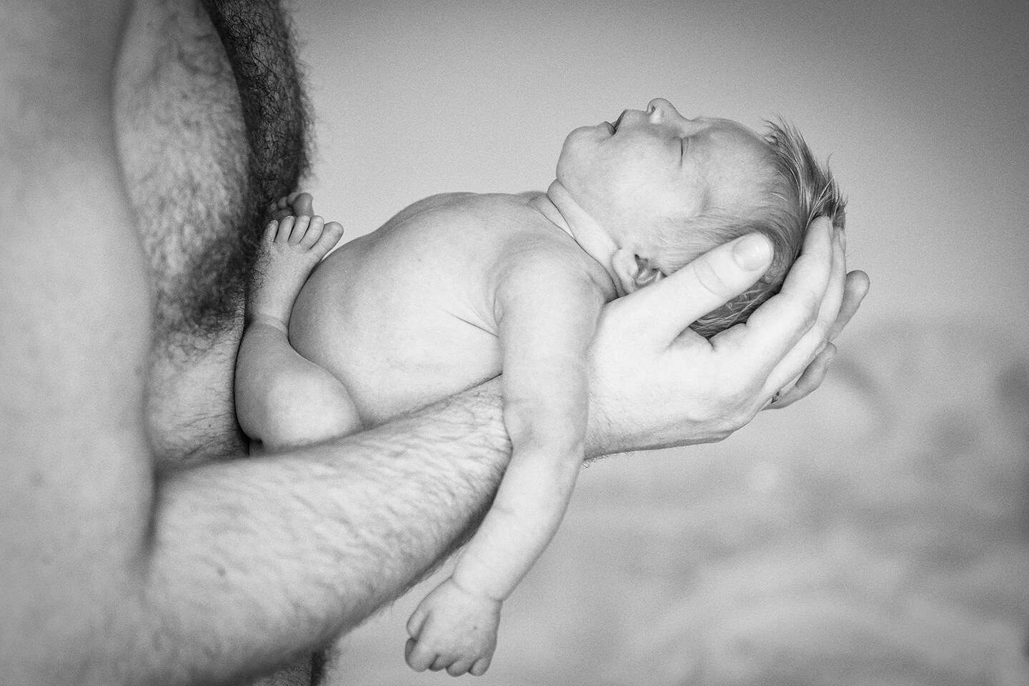 Schlafendes Baby bei Papa in den Händen