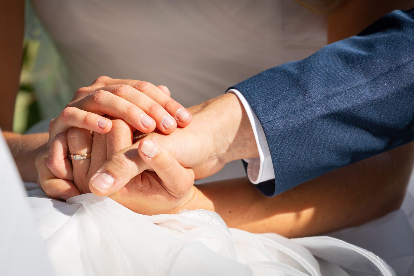 Braut und Bräutigam halten Hände bei der Trauung
