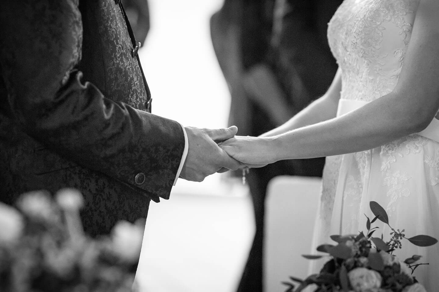 Braut und Bräutigam halten sich die Hände
