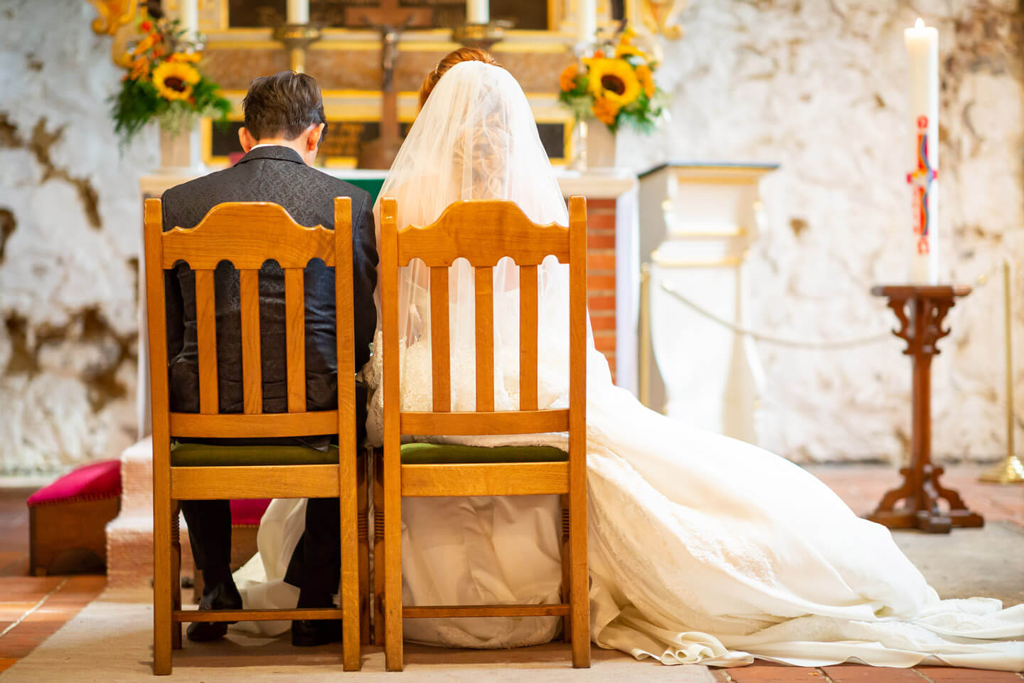 Brautpaar sitzt vor dem Altar