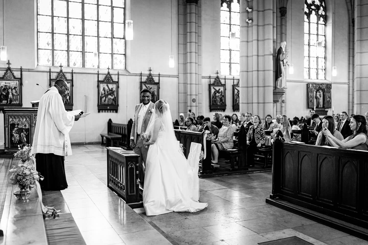 Brautpaar und Pfarrer am Altar.