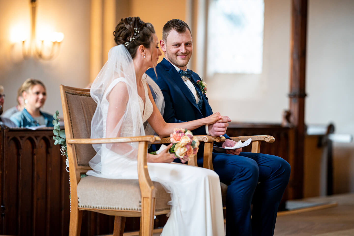 Bräutigam guckt seine Braut in der Kirche verliebt in die Augen.