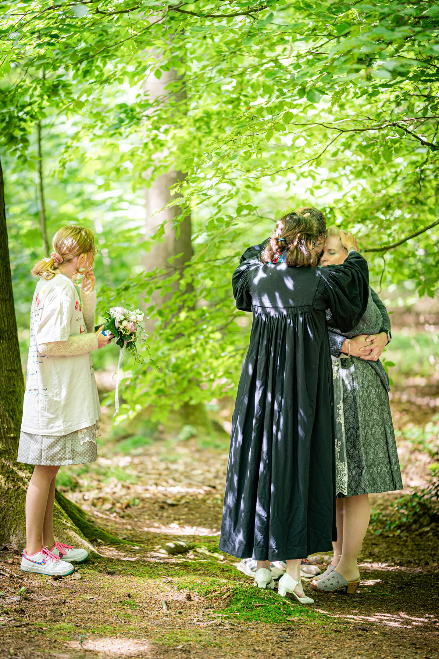 Pastorin segnet das Brautpaar bei einer Hochzeit im Wald.