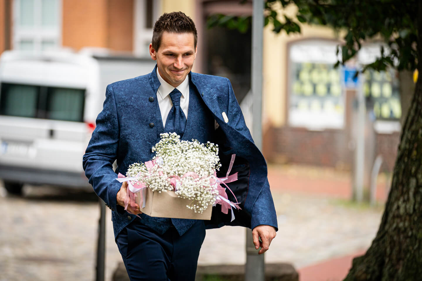 Bräutigam bringt Blumenschmuck in die Kirche.