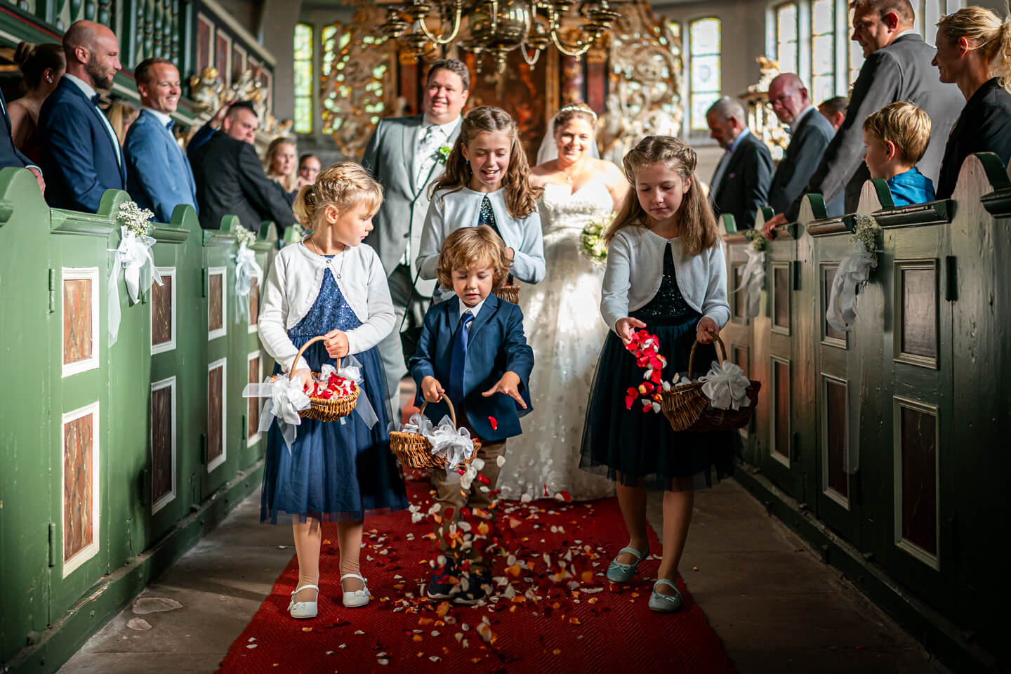 Blumenkinder streuen Blütenblätter in der Moorburger Kirche nach einer Hochzeit.