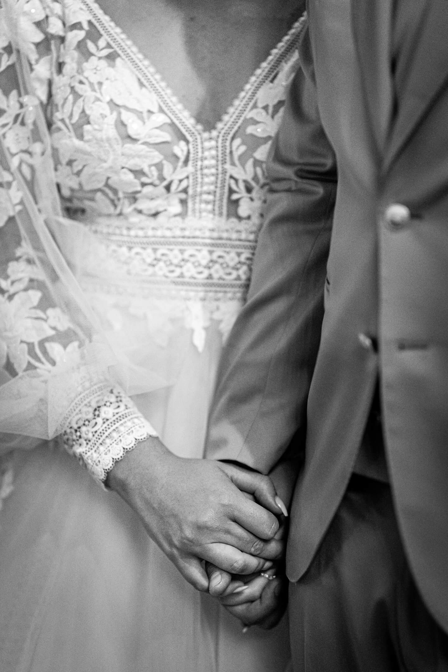 Brautpaar hält sich die Hände.