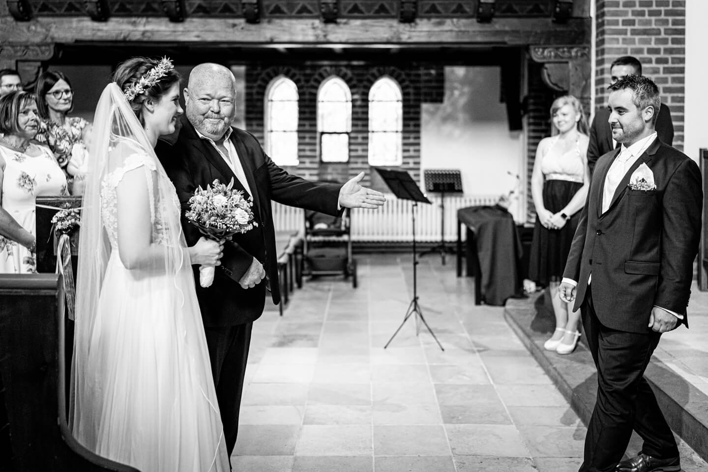 Im richtigen Moment auf den Auslöser der Kamera gedrückt: Der Brautpapa übergibt seine Tochter an den Bräutigam.